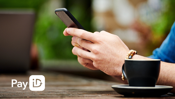 Hand holding a mobile with coffee cup